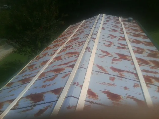 Rusted metal roof panels with new wood purlins before replacement — Storm Damage Roof Repair in Chino Valley by Roofing Brothers
